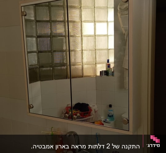 אריחי זכוכית ליד מראה בחדר אמבטיה